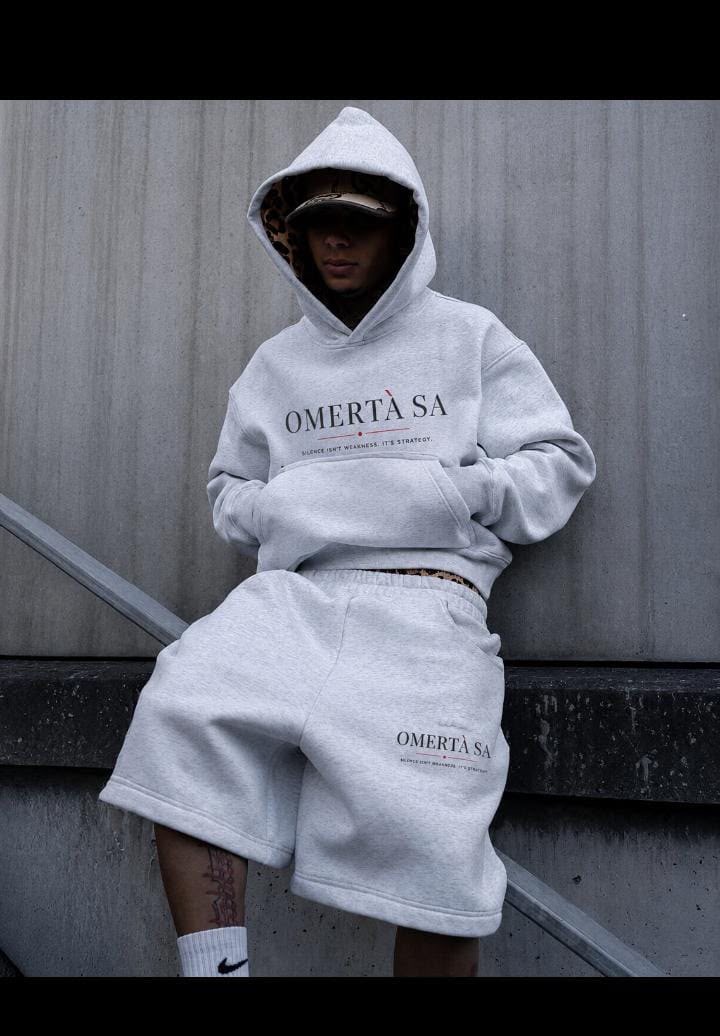 Omertà SA grey hooded sweatshirt and matching shorts worn on concrete steps